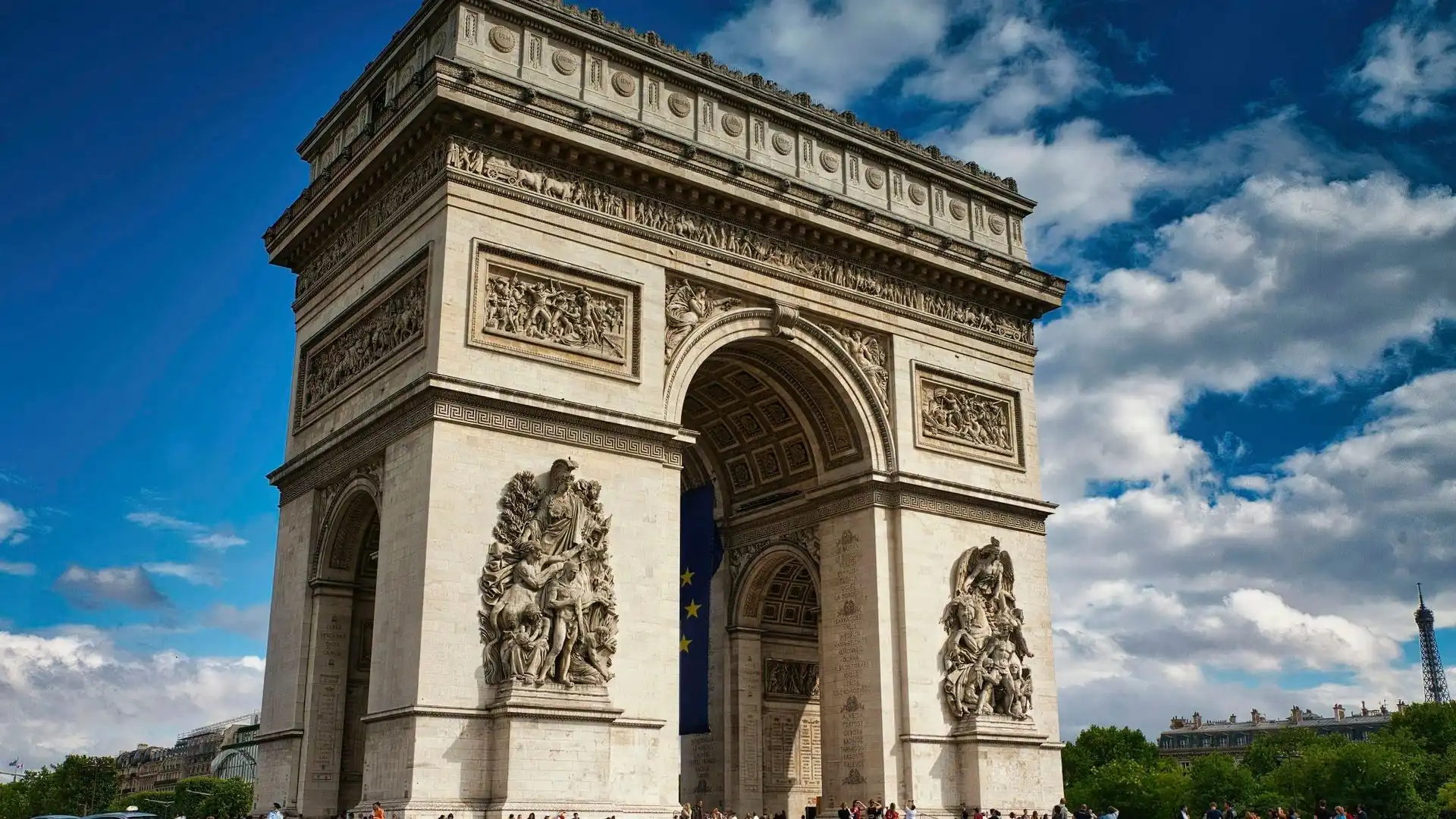 Arc de Triomphe at the top of the Champs-Élysées under a blue sky Arc de Triomphe at the top of the Champs-Élysées under a blue sky