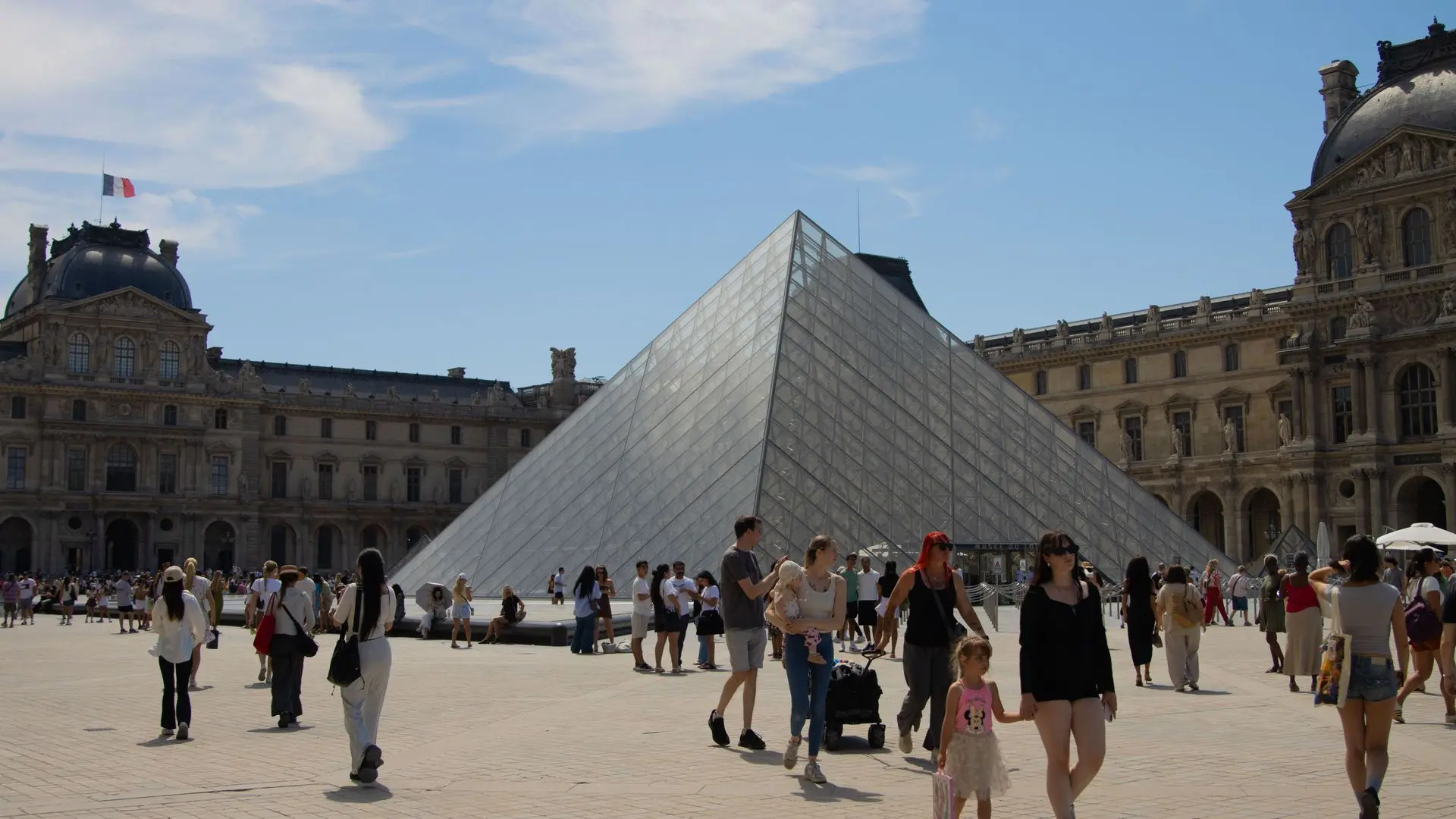 Visitors in the Cour Napoléon around the Louvre pyramid