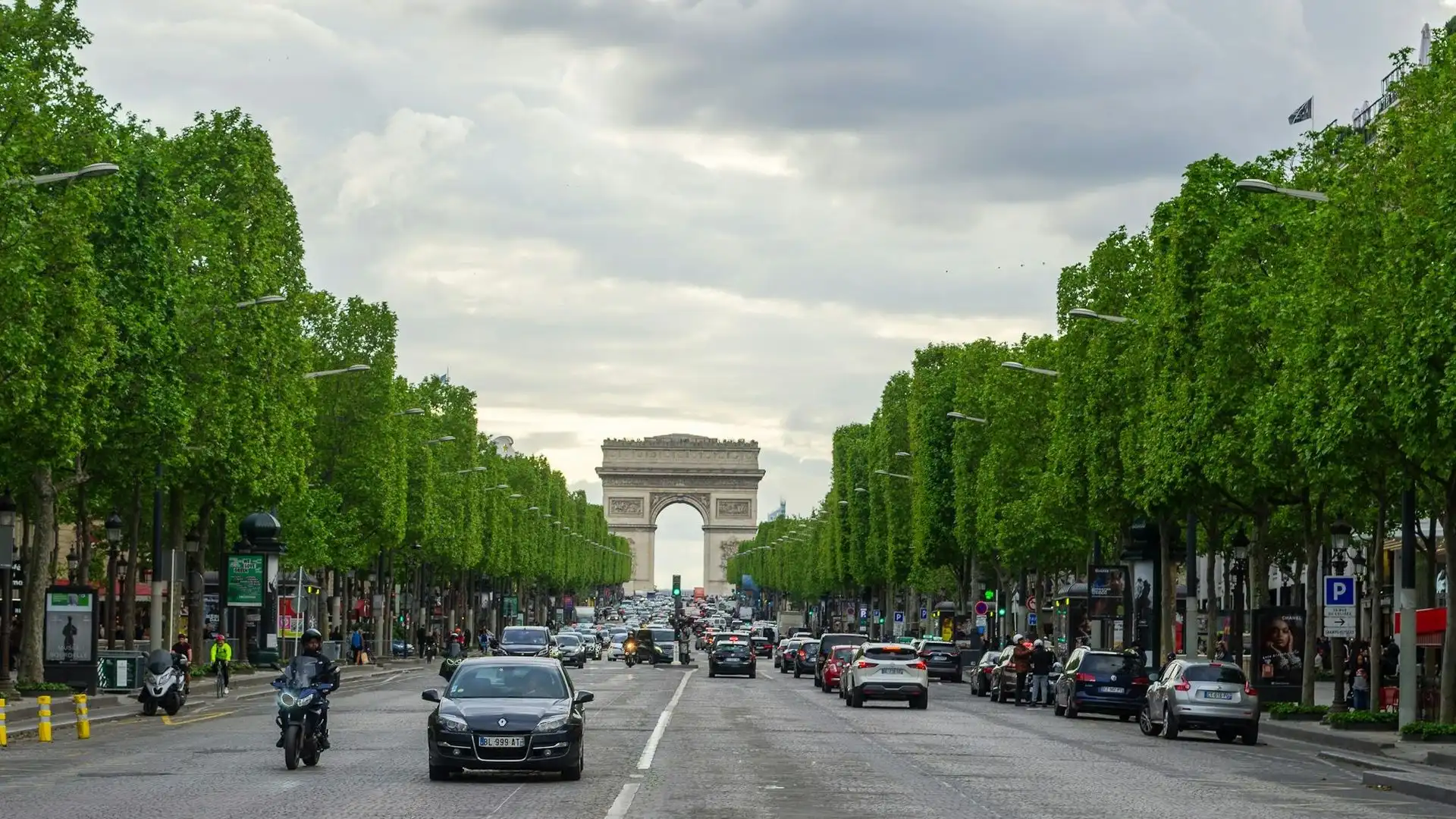Traffic on the tree-lined Champs-Élysées leading up to the Arc de Triomphe Traffic on the tree-lined Champs-Élysées leading up to the Arc de Triomphe