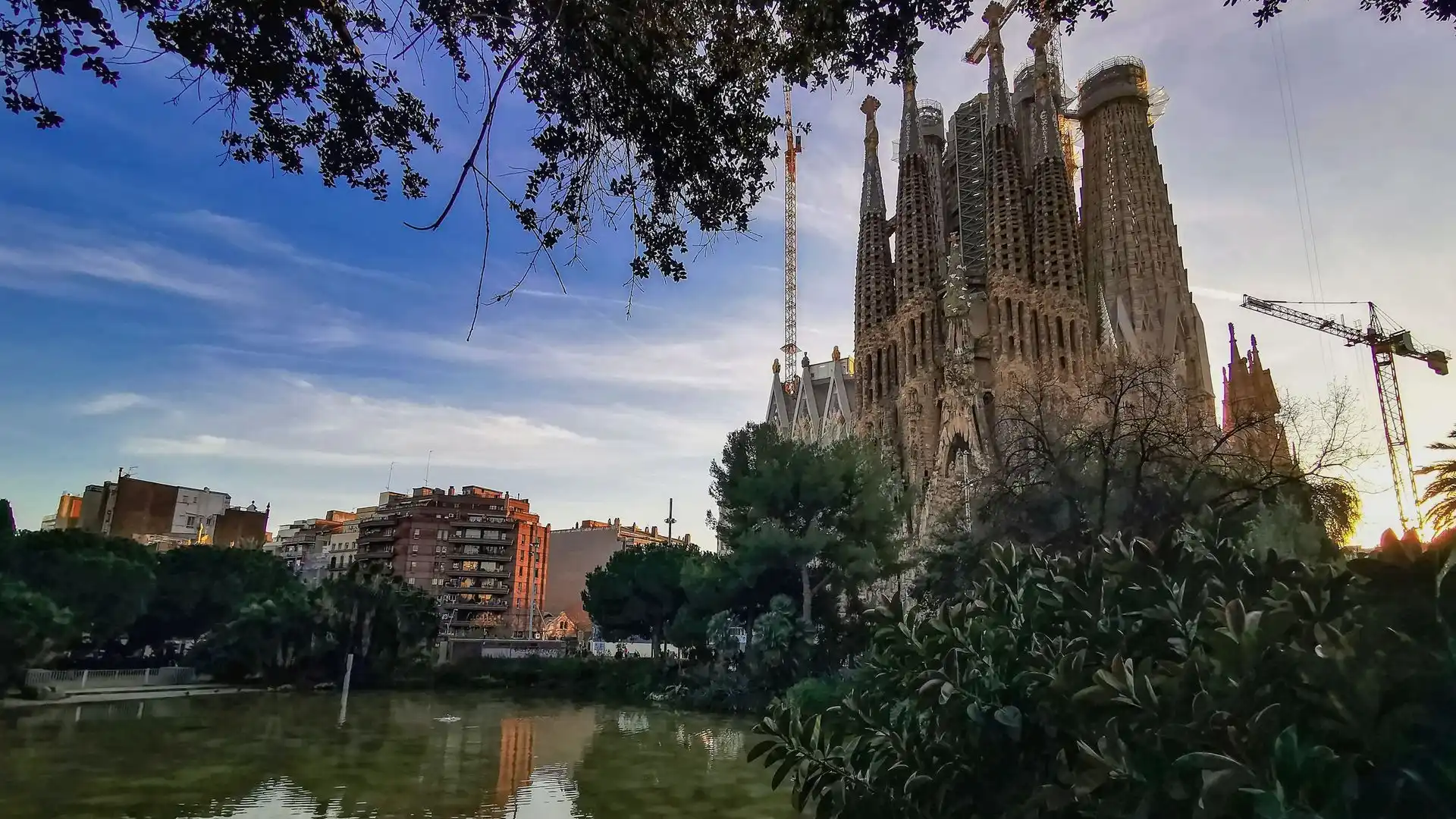 Sagrada Familia towers in Barcelona seen across the park pond Sagrada Familia towers in Barcelona seen across the park pond