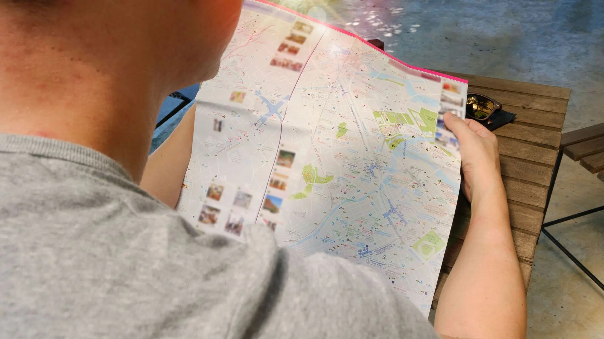 Traveller studying a fold-out Paris city map Traveller studying a fold-out Paris city map