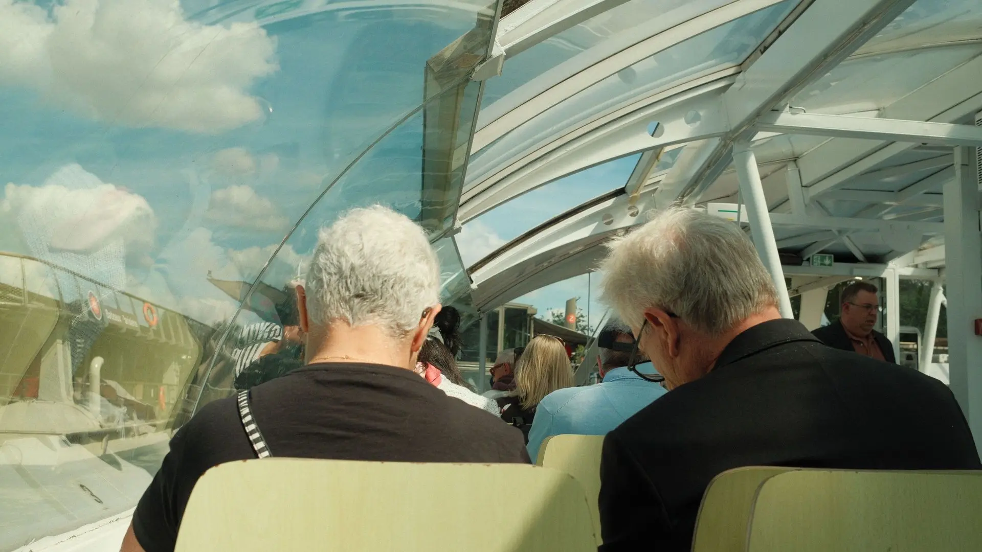 Passengers under the glass roof of a river boat on the Seine Passengers under the glass roof of a river boat on the Seine