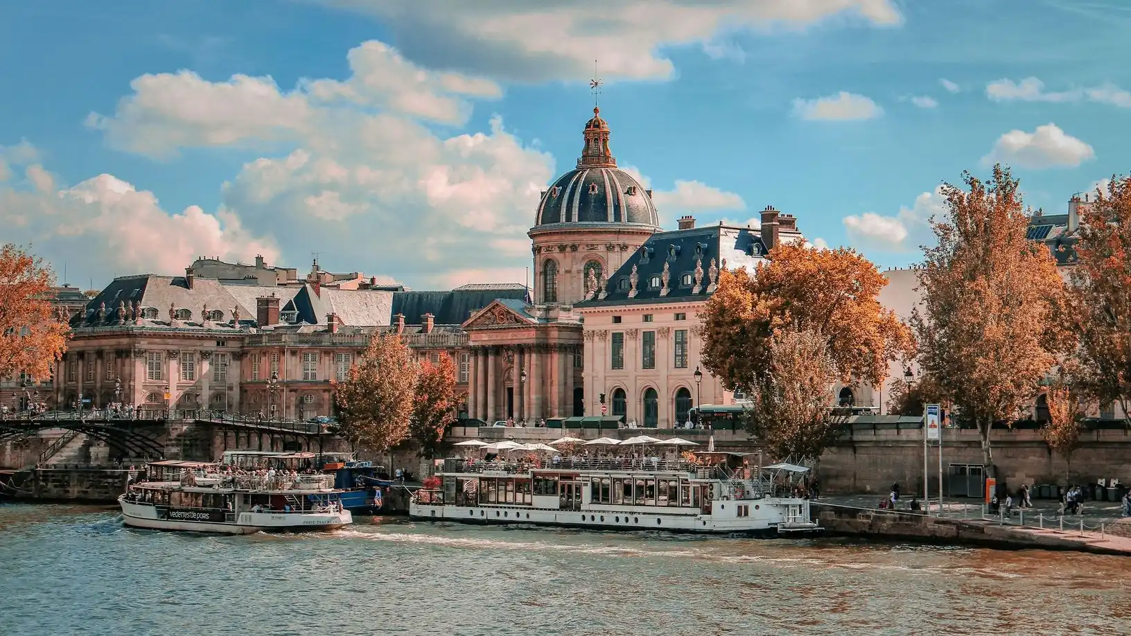 River boats moored on the Seine below the dome of the Institut de France River boats moored on the Seine below the dome of the Institut de France