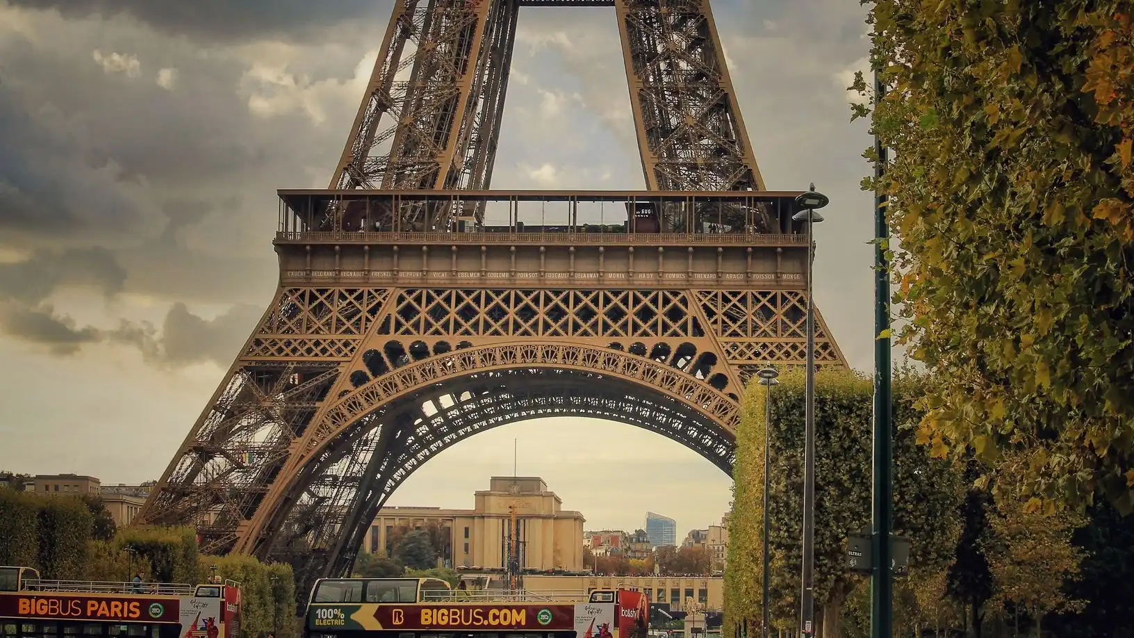 Sightseeing buses on the road at the foot of the Eiffel Tower Sightseeing buses on the road at the foot of the Eiffel Tower